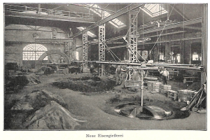 Ein altes Schwarz-Weiß-Foto einer Fabrik mit Menschen, die an einer Maschine arbeiten, umgeben von Metallstangen und -pfählen, mit dem Text "Neue Eisenglebeerei, die erste Fabrik Deutschlands" unten.