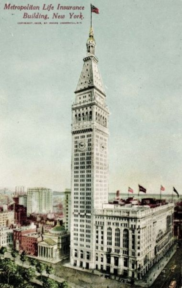 Schwarz-weiß-Postkarte des Metropolitan Life Insurance Building in New York City, die eine belebte Straße mit Gebäuden, Bäumen und Fahrzeugen zeigt und den Text "Metropolitan Life Insurance" oben trägt.
