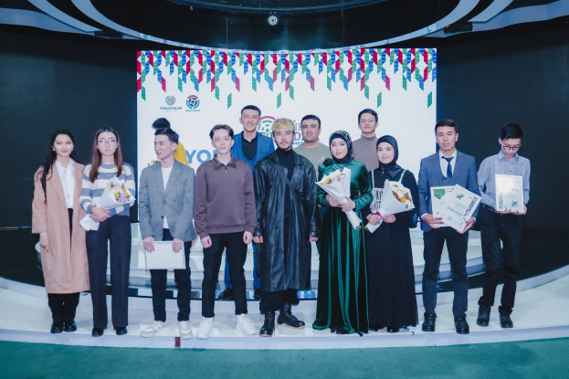 Eine Gruppe von Menschen auf einer Bühne mit Blumensträußen und Urkunden, im Hintergrund ein "Youth Solar Awards 2019"-Schild.