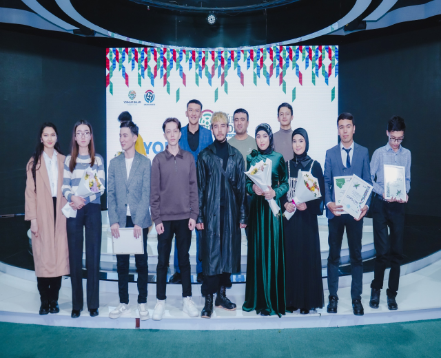 Eine Gruppe von Menschen auf einer Bühne mit Blumensträußen und Urkunden, im Hintergrund ein "Youth Solar Awards 2019"-Schild.