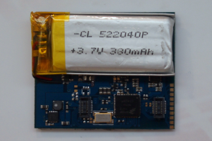 Nahaufnahme einer Handy-Batterie mit gedrucktem Text auf einer Platine, die auf einer weißen Oberfläche liegt.