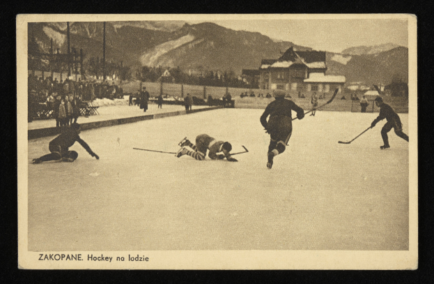 Schwarz-weißes Foto von Menschen, die Hockey auf einem Eisplatz mit Gebäuden, Bäumen, Pfählen und Bergen im Hintergrund spielen, einschließlich Text unten.