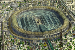 Luftaufnahme eines großen Stadions in einer städtischen Umgebung, umgeben von Gebäuden, Bäumen und Gras.