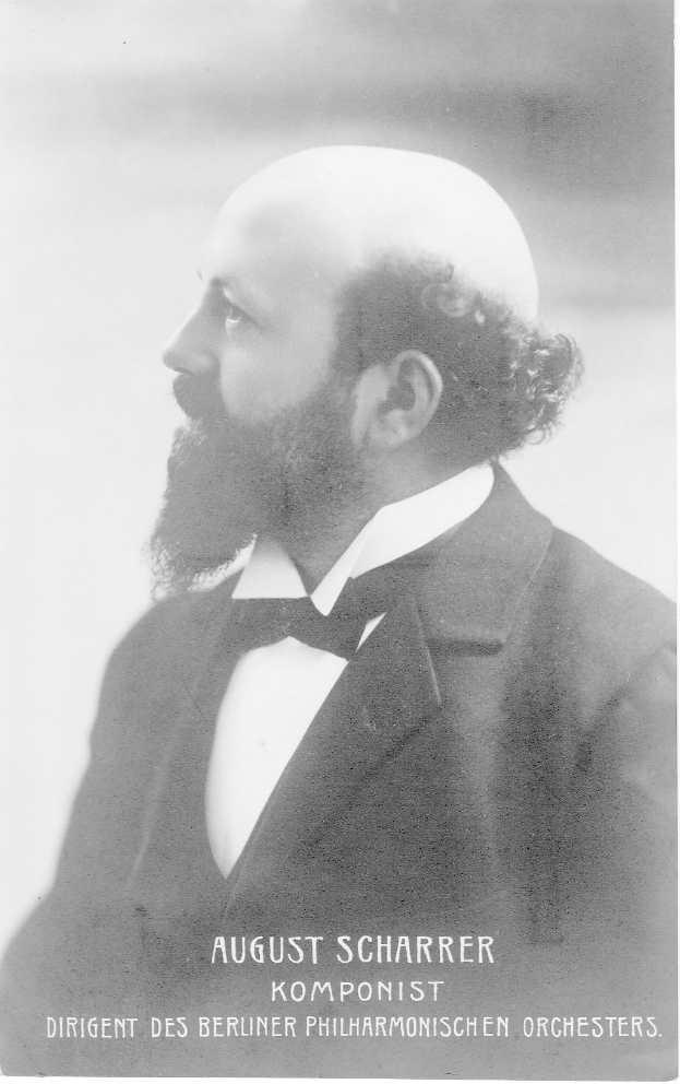 Ein Schwarz-Weiß-Foto von August Scharrer, einem deutschen Komponisten, der einen Blazer und eine Fliege trägt, mit Text unten auf dem Bild.