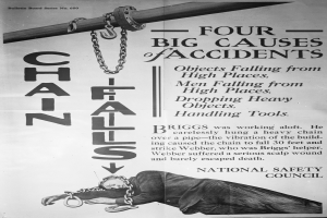 Ein schwarzes und weißes Plakat mit einer Person auf einem Pfahl liegend und Ketten daran befestigt, mit der Aufschrift "Vier große Unfallursachen".