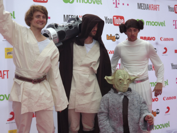 Gruppe von Menschen in Star Wars-Kostümen, die auf einem roten Teppich posieren.