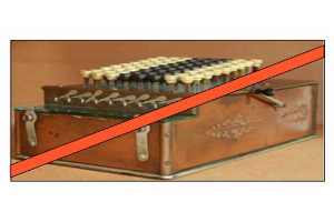 Eine alte Kasse mit einem roten Kreuzsymbol darauf, die auf einem Tisch steht und Knöpfe und ein rotes Band hat.