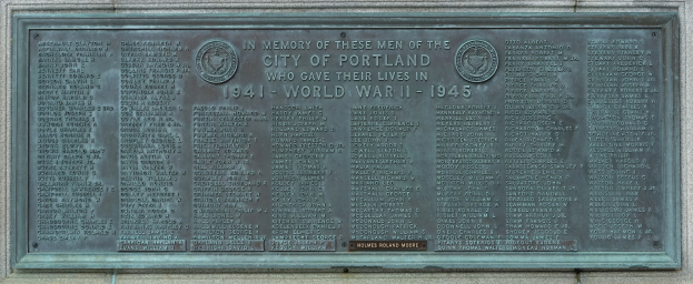 Metallplatte an einer Gebäudewand mit fetter schwarzer Schrift, die "Denkmal für die Stadt Portland" lautet, umgeben von einem dekorativen Rahmen.